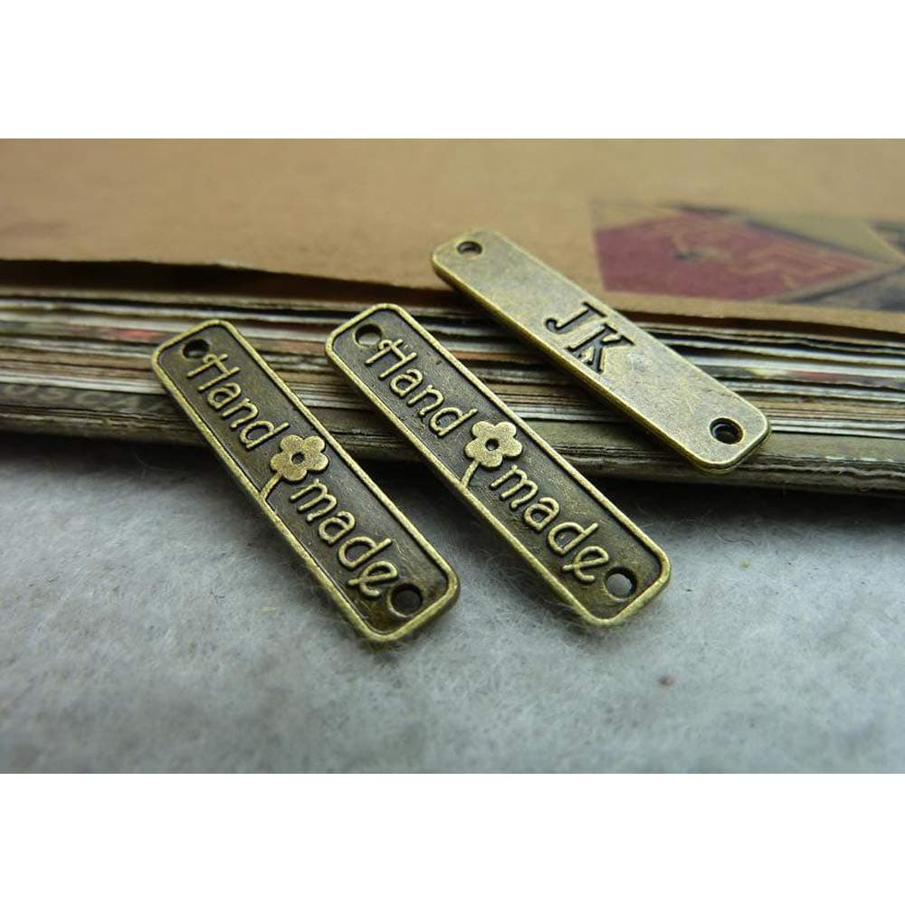 EvaGO 100 Pieces 24x5mm Metal Handmade Tag Label Handmade Tags Button with 2 Holes Metal Tag Signs for Jewelry Making Crafts, Sewing Clothing Decorations